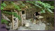 Shelter for survival in the forest. Construction of a house near a stream